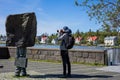 A tourist taking photo of a Monument to the Unknown Bureaucrat, Reykjavik. Royalty Free Stock Photo